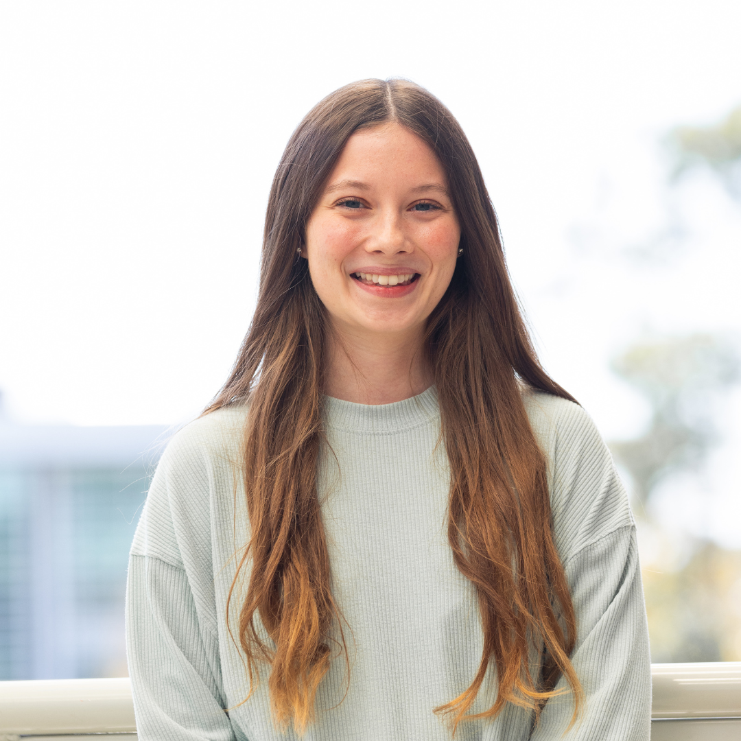 Savanna wears a light color shirt and smiles at the camera