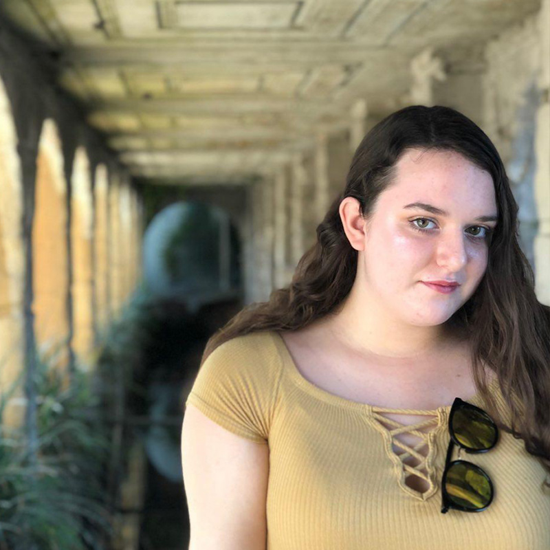 Skylar in a yellow shirt under a pier