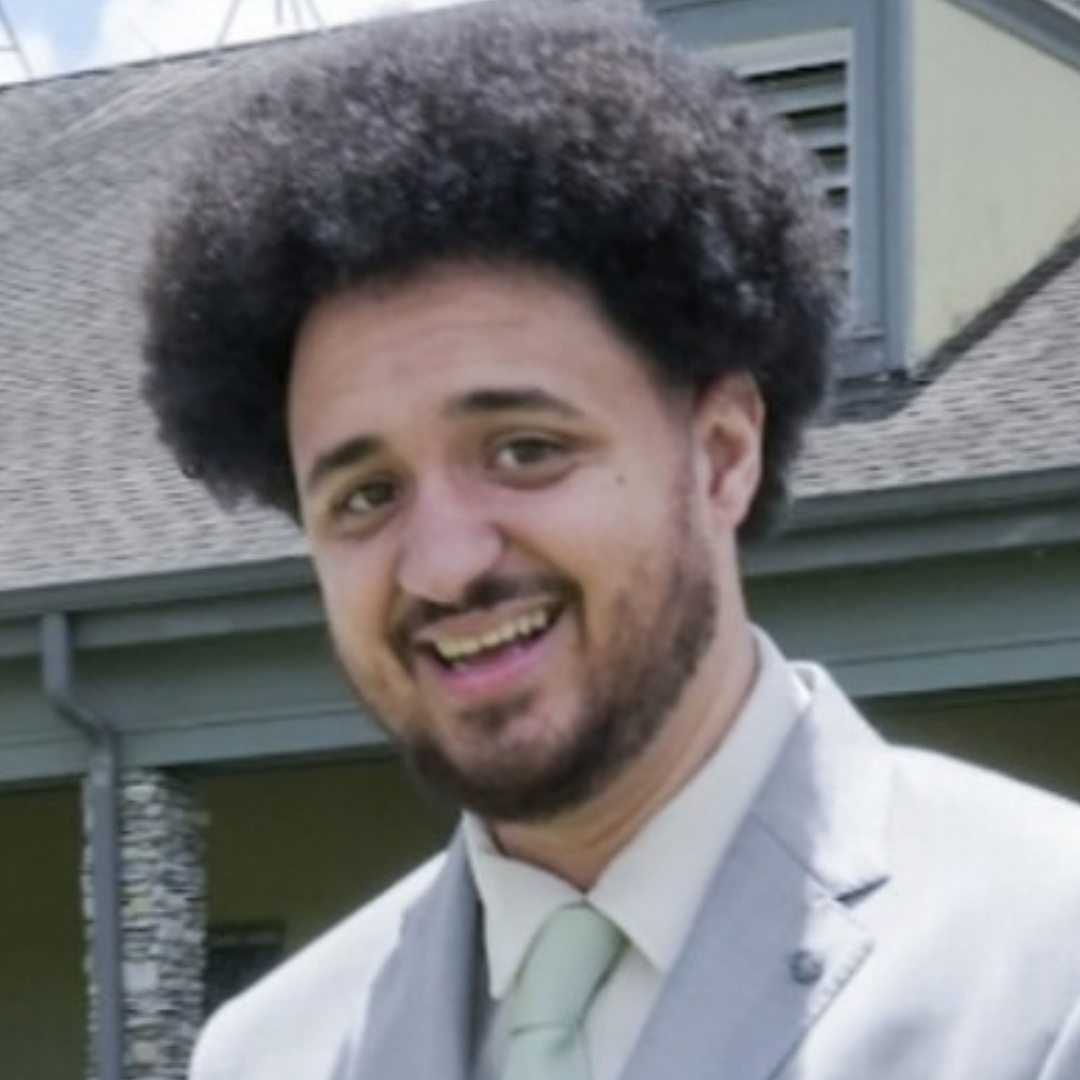 Tre is standing outside in a suit and tie