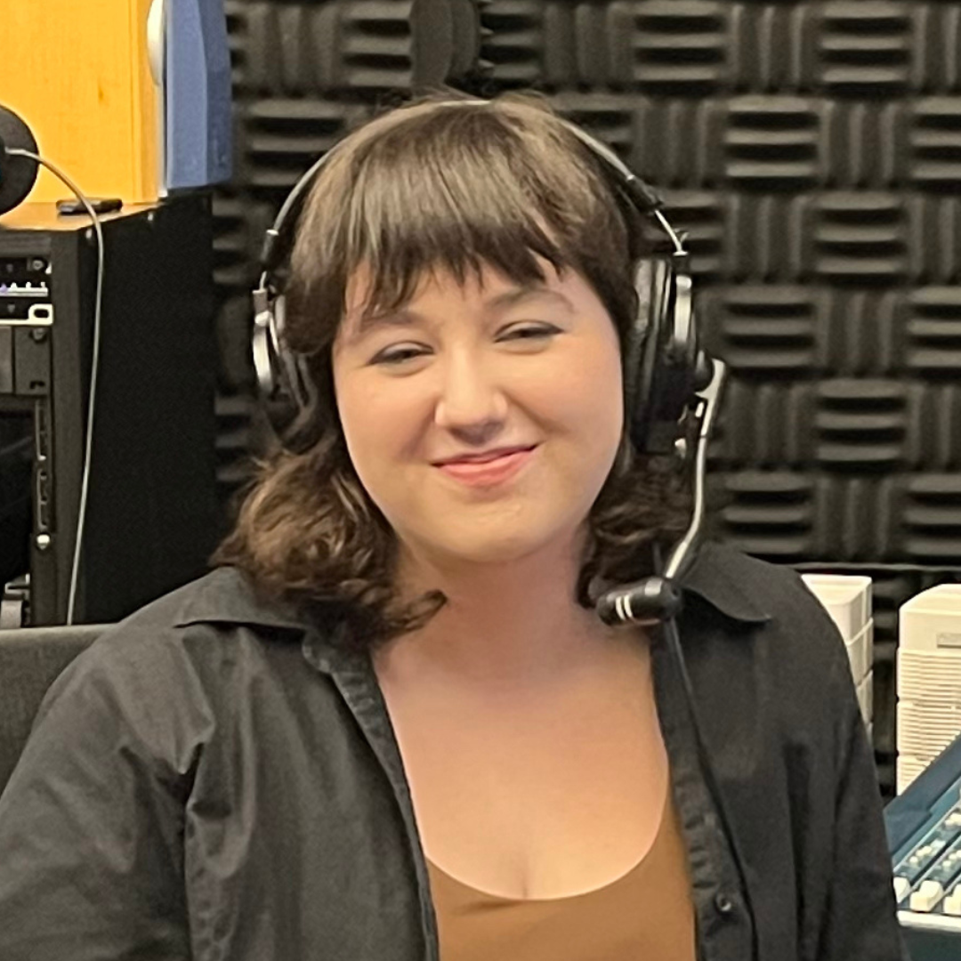 Violet is wearing a headset and sitting in Radio's live booth