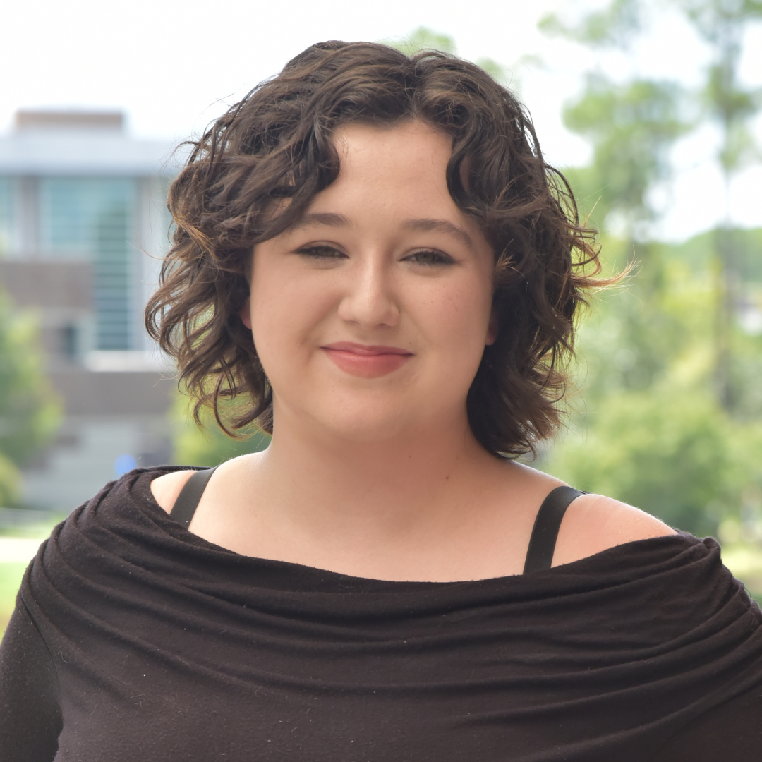 Violet has short black hair and is wearing a black shirt. 