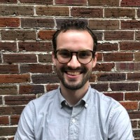 Kevin stands in front of a brick wall