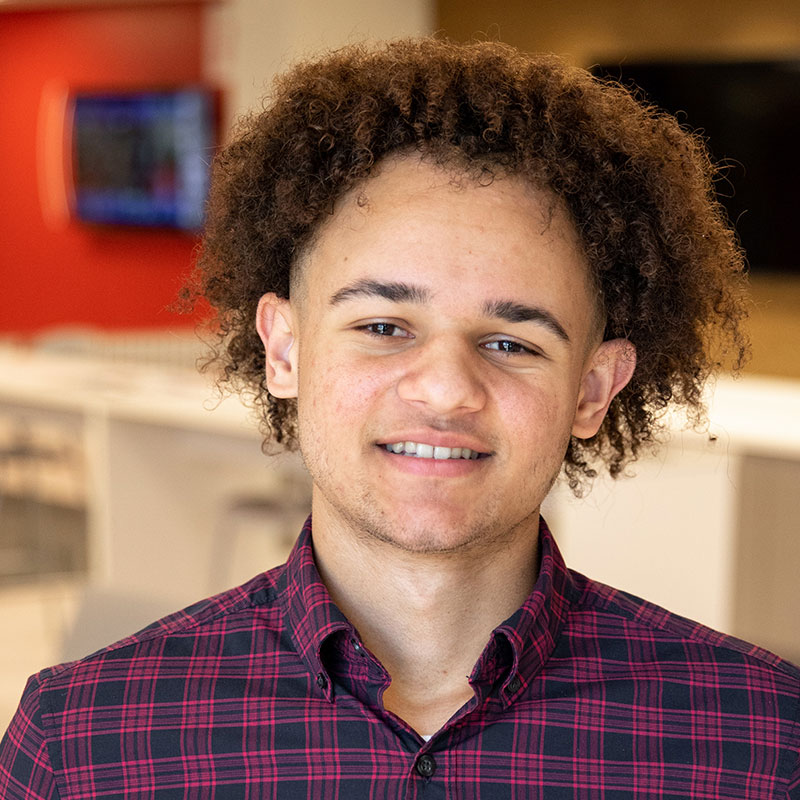 Winston Davis in a red plaid shirt standing in an office