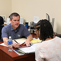 advisor working with a student at a desk