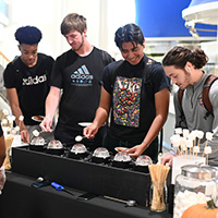 students laughing while roasting marsh mellows at market day