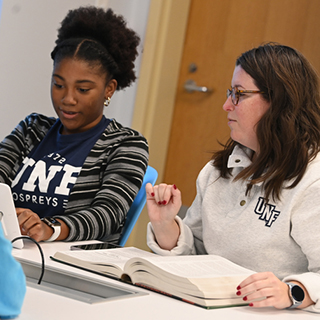 students working together on a project with a book open