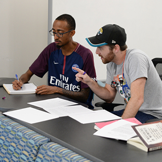 students working in the writing center writing in notebooks