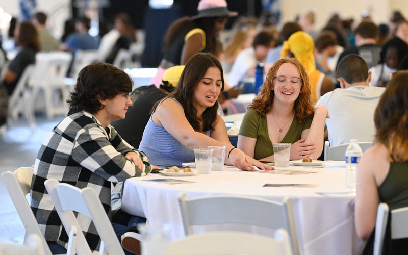 three students at a table conversing during flight school