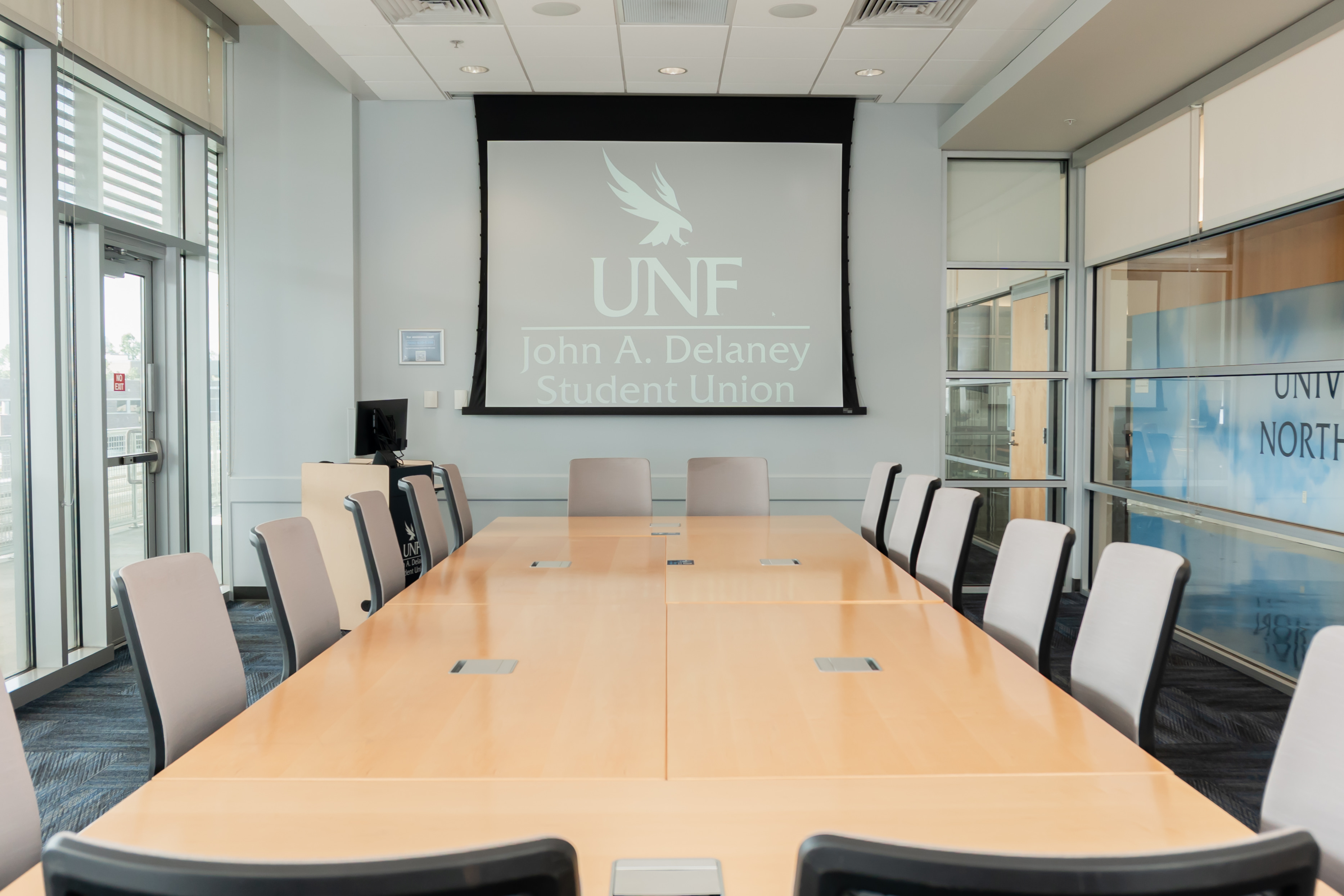 conference room with large table, chairs and projector screen