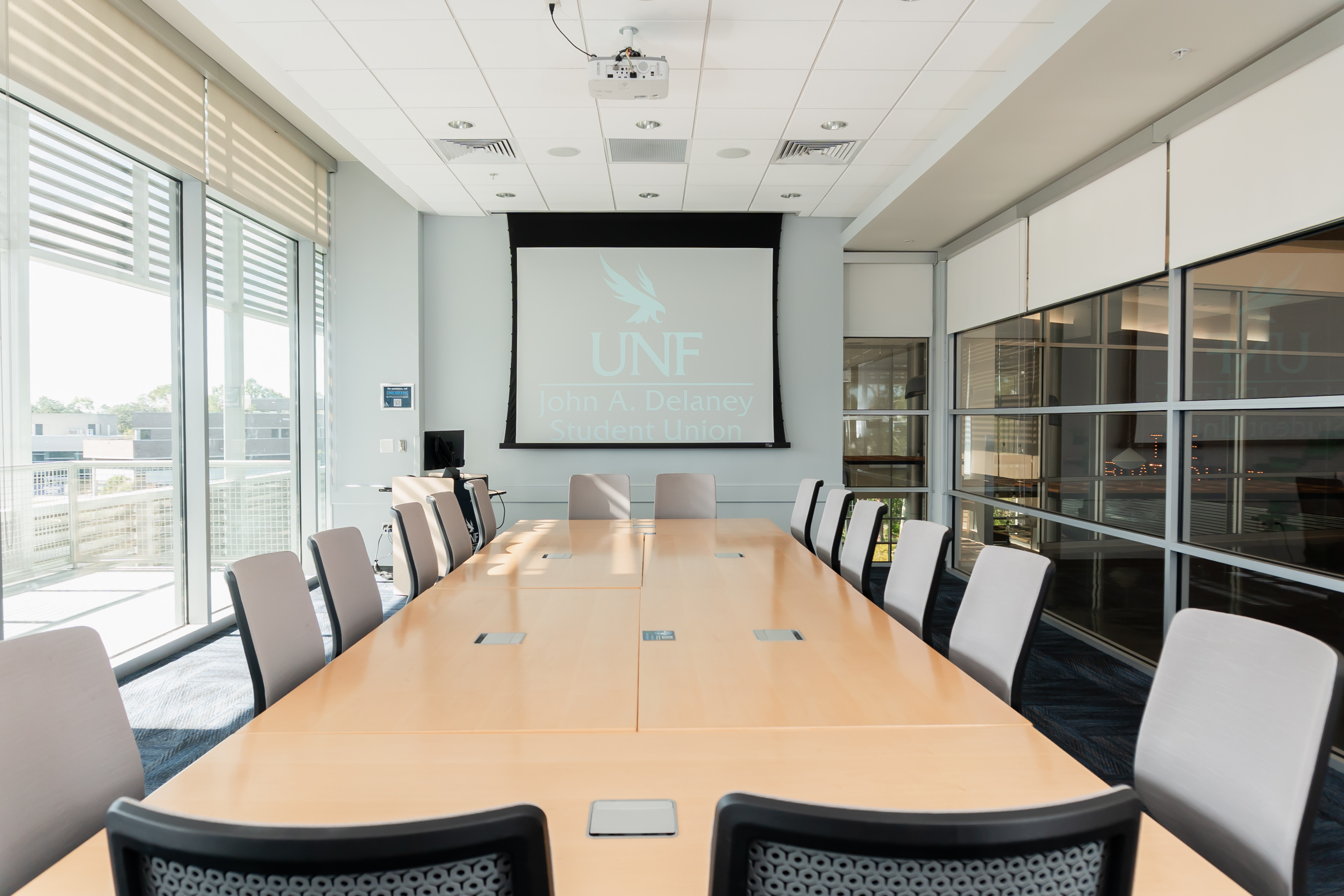 conference room with large table, chairs and projector screen