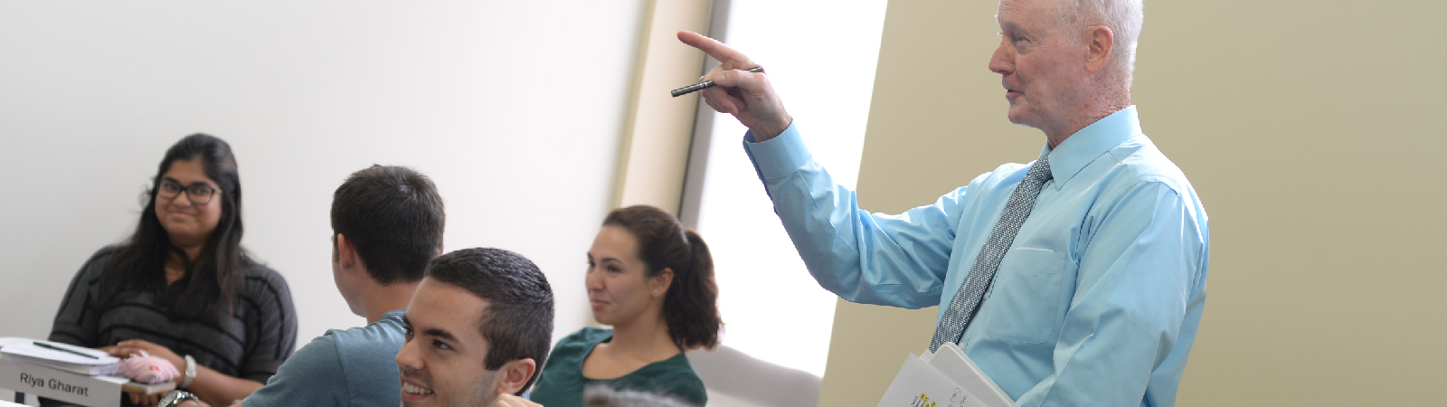 Rick Tryon standing in front of a classroom pointing with students sitting nearby