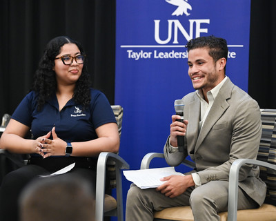 Students sitting in chairs presenting on stage during Taylor Talks event.