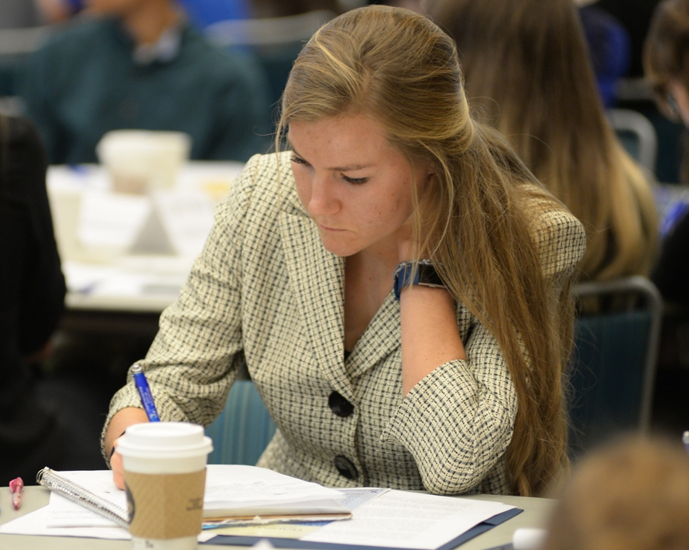 Female students sitting at a table completing work on paper