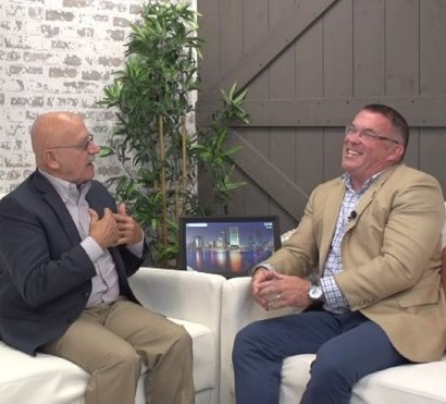 Dr. Ohlson sitting on a couch being interviewed by Buzz Daily News