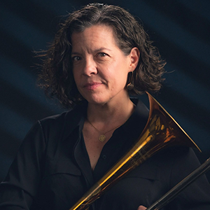 Headshot of Jennifer Krupa holding a trombone