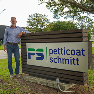 Photo of Ryan Schmitt standing in front of his business's sign
