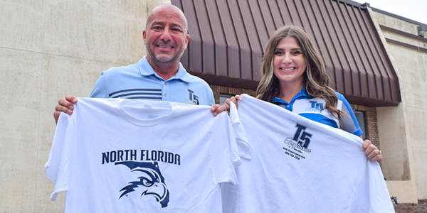 UNF alumni holding up UNF shirts