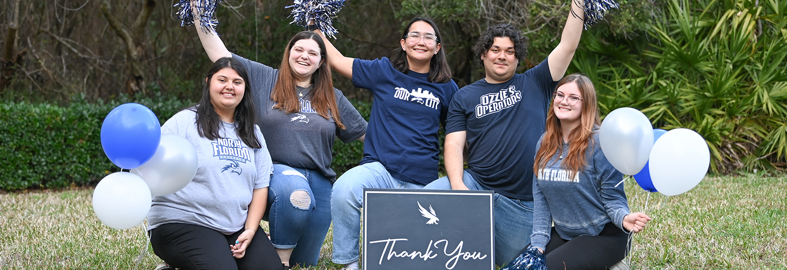 Students smiling with a sign that says Thank you