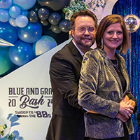 Couple posing at blue and gray bash