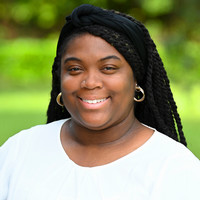 A woman smiling for a professional headshot photograph.