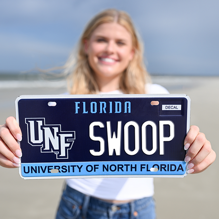 unt sudent holding up a swoop license plate