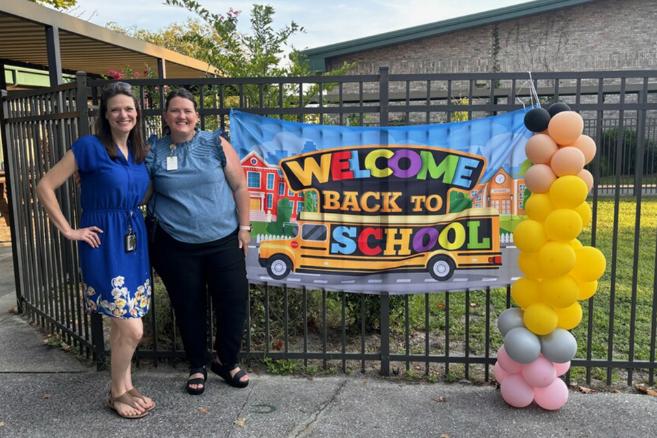 Ayers and teacher with a welcome back to school sign
