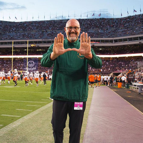 bo holding up the u logo on the football field