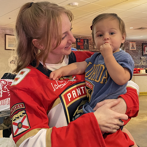 Sean Thurman wearing Panthers jersey holding baby