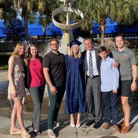 Courson family celebrating Anastasia's graduation by fountain