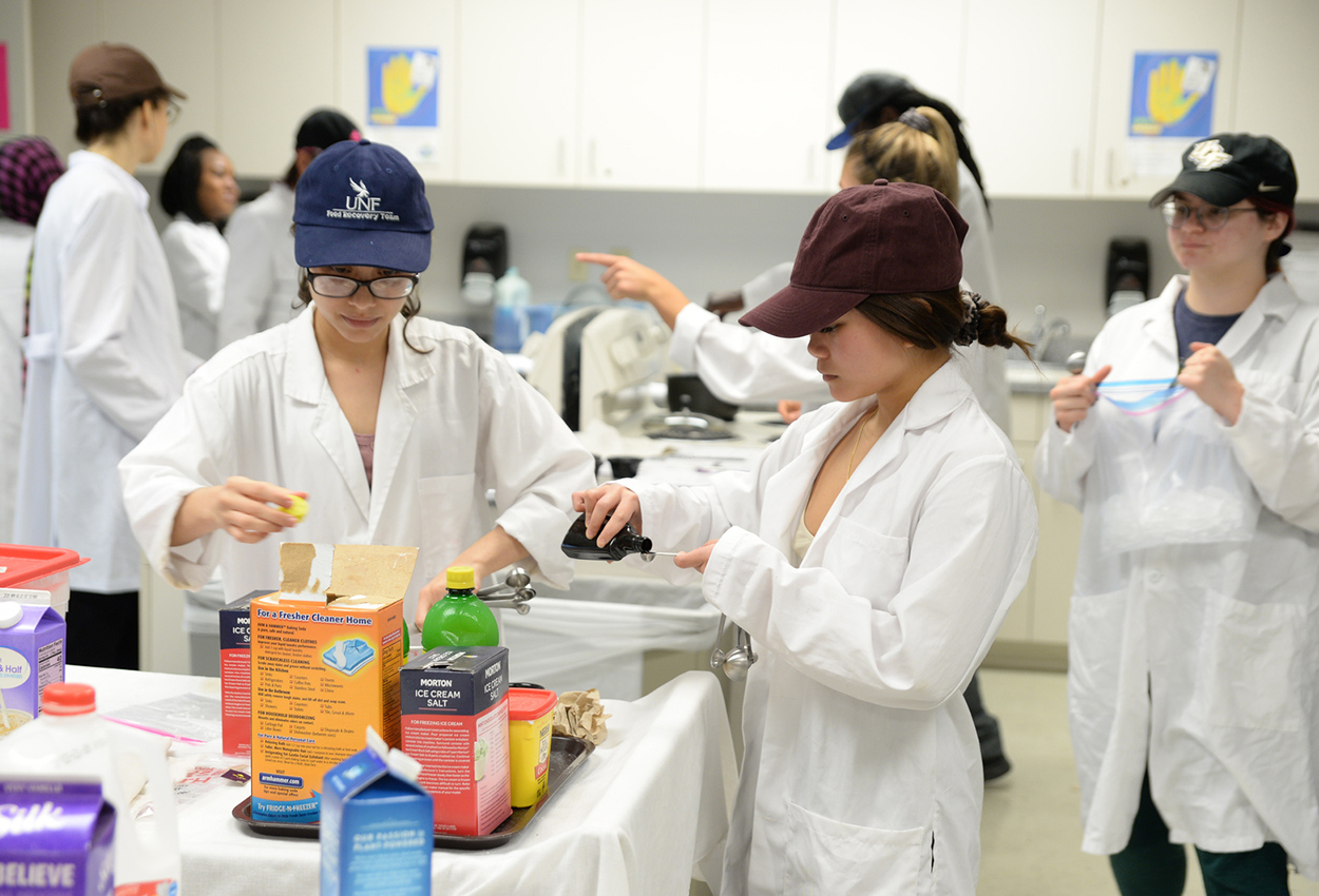 Brooks nutrition students working on a project in the lab with various food items and chemicals