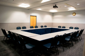 tables aligned in a rectangle in empty classroom