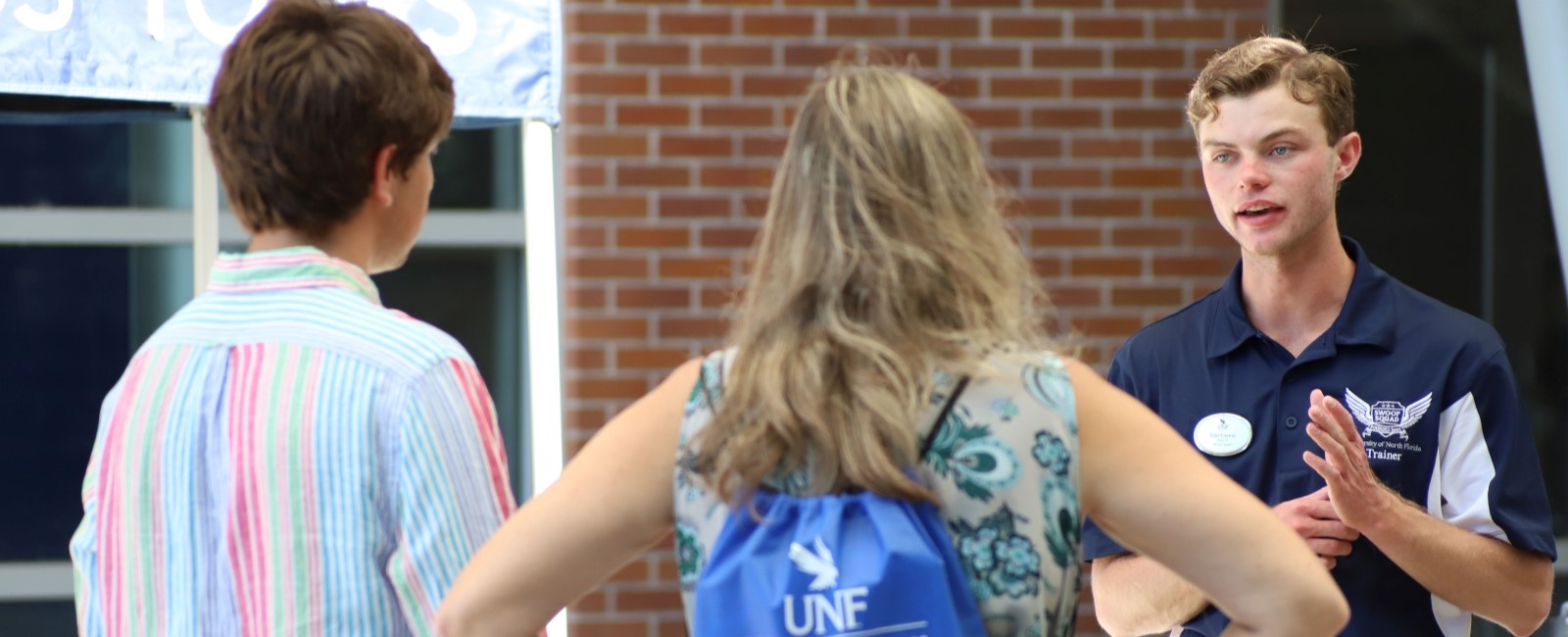 A UNF student tour guide talking to tour guests.