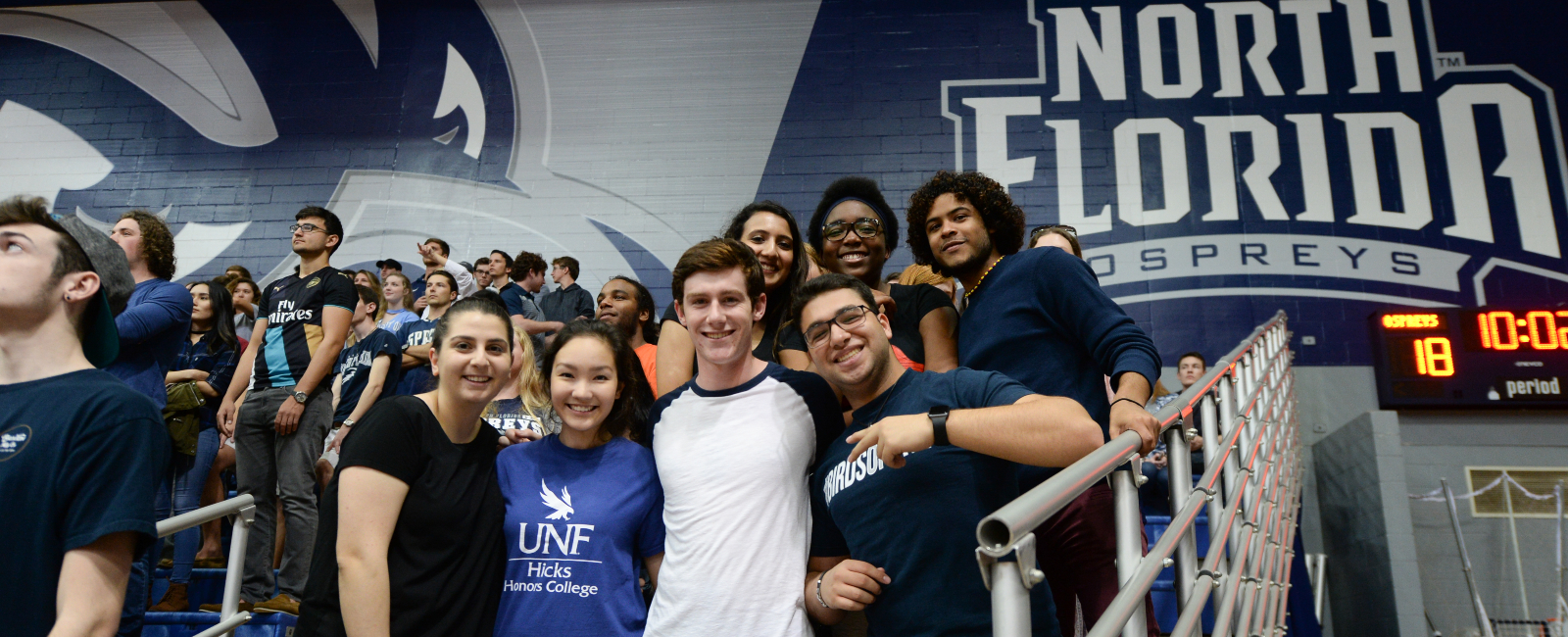 Large group of students at a UNF basketball game all grouped together and smiling