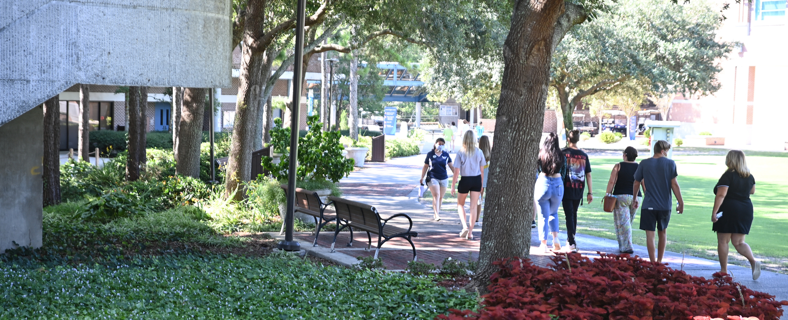 Tour group walking through UNF's campus following a female tour guide