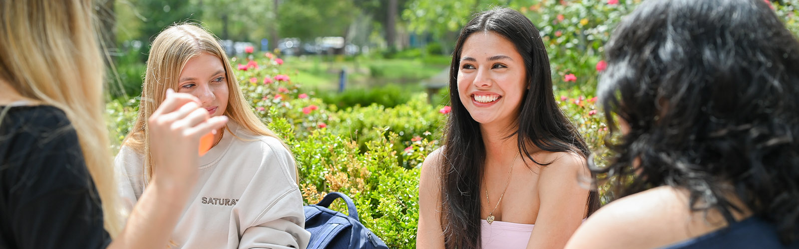 Four women sitting on campus talking