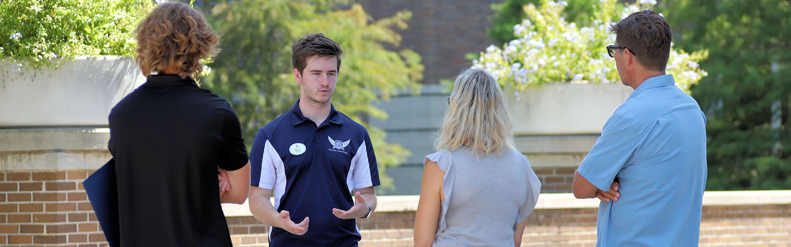 student tour guide talking to a visiting family on campus