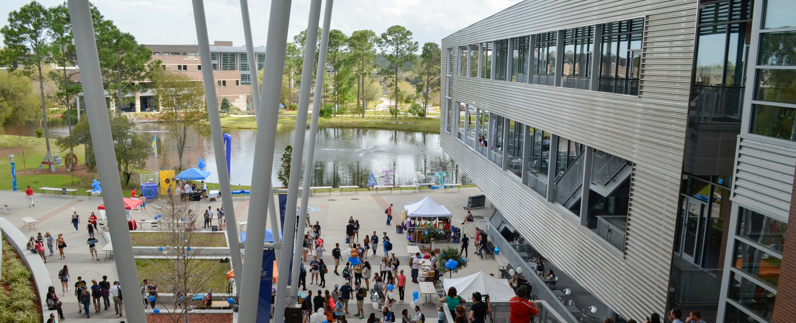 The John A. Delaney Student Union courtyard filled with students with a lake in the background