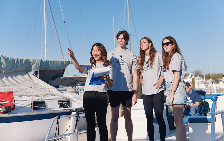 Students working together in front of a boat